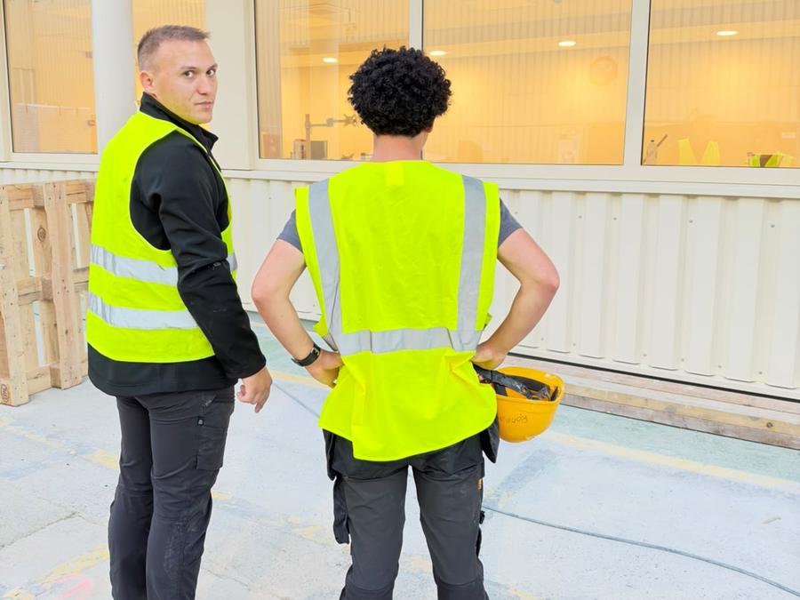 Équipe GomaClean devant les baies vitrées d'un site professionnel
