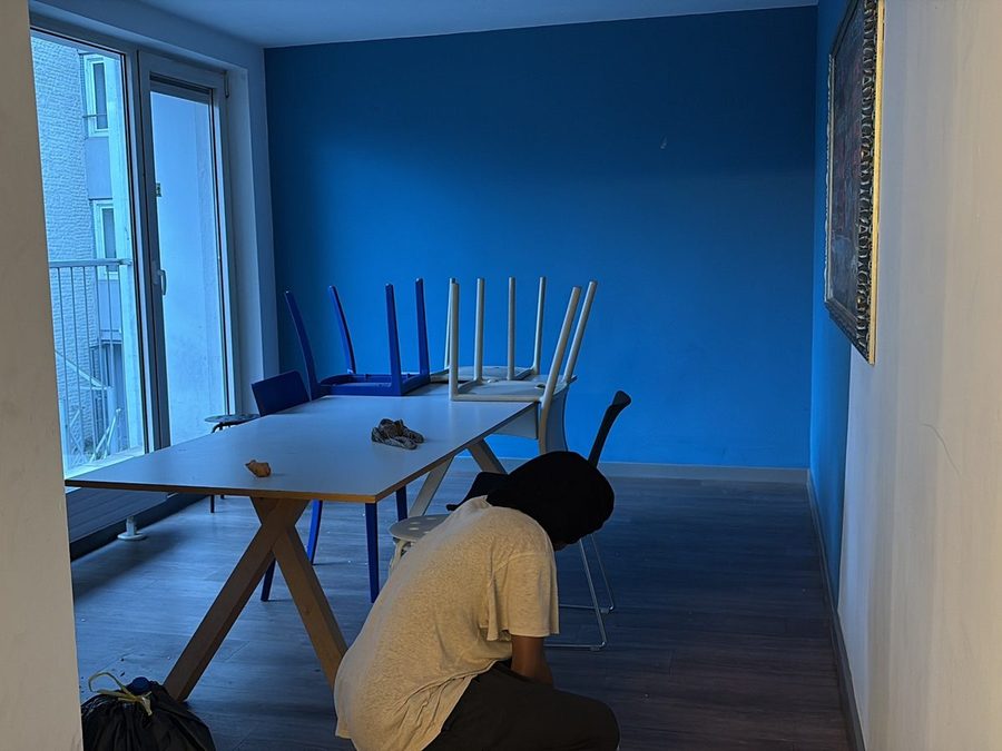 Agent GomaClean nettoyant une salle à mur bleu après un événement